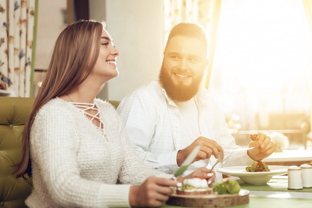 Feliz homem e mulher almoçar em um restaurante