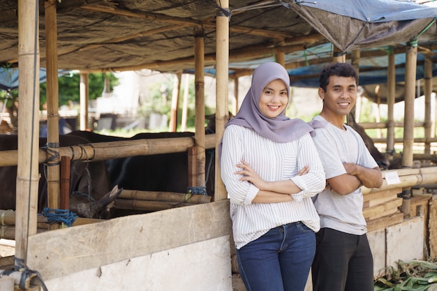 Feliz homem e mulher em pé na fazenda. conceito de sacrifício eid adha