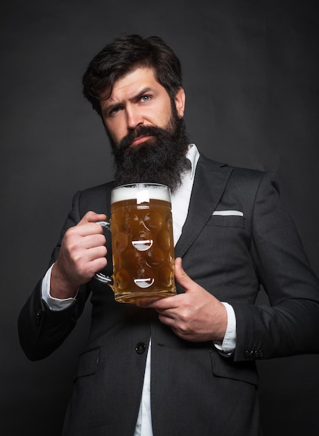 Feliz homem elegante bebendo cerveja homem sênior de terno preto bebendo cerveja com cara de surpresa