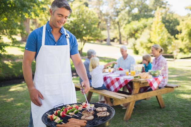 Feliz homem fazendo churrasco para sua família