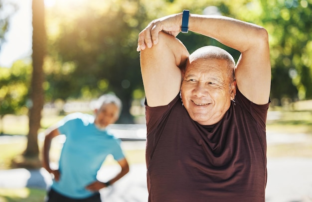 Feliz homem sênior, alongamento e fitness no parque para exercícios de corrida ou treinamento ao ar livre na natureza Pessoa madura do sexo masculino no corpo aquece alongamento de braço ou preparação para treino cardiovascular ou bem-estar