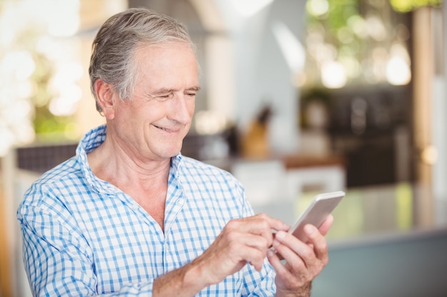 Feliz homem sênior usando telefone celular