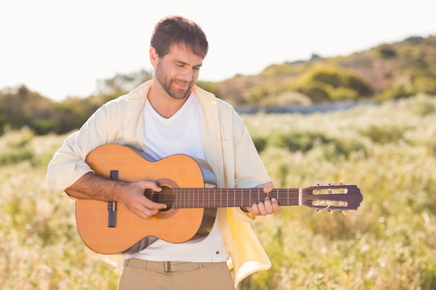 Feliz, homem, sorrindo, câmera, tocando, violão