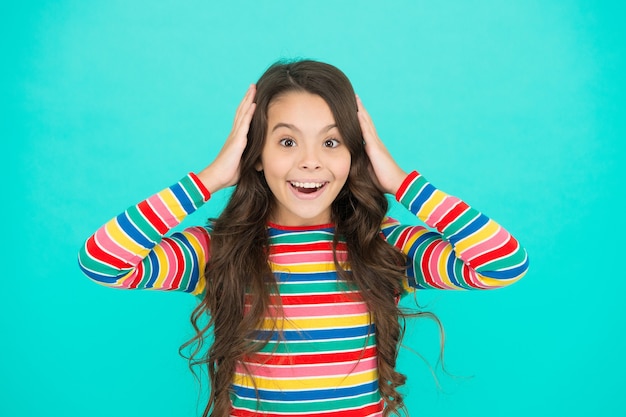 Foto feliz infancia emociones positivas jovencita sonriente fondo turquesa niño adolescente con pelo largo