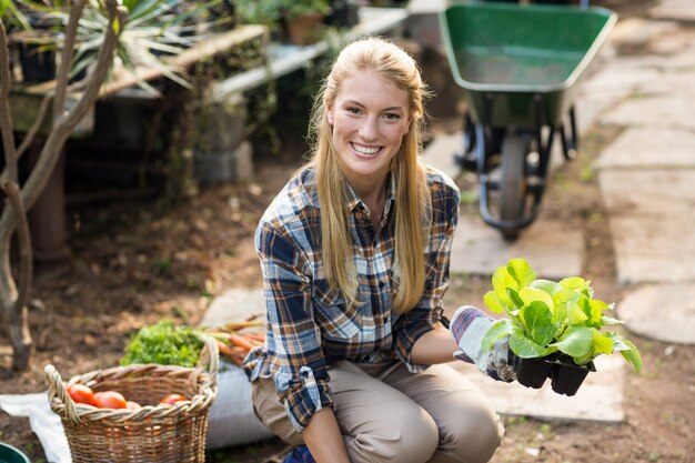 feliz jardinero mujer sosteniendo pimpollo