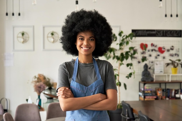 Foto feliz jovem africana café pequena empresa proprietária de braços cruzados