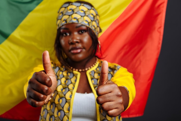 Foto feliz jovem africana sorridente com a bandeira da república do congo em segundo plano