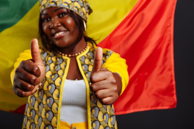 Foto feliz jovem africana sorridente com a bandeira da república do congo em segundo plano