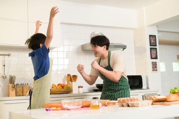 Feliz jovem asiático pai e filho cozinhando na cozinha em casa