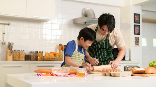 Feliz jovem asiático pai e filho cozinhando na cozinha em casa