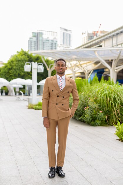 feliz jovem bonito empresário africano sorrindo ao ar livre na cidade