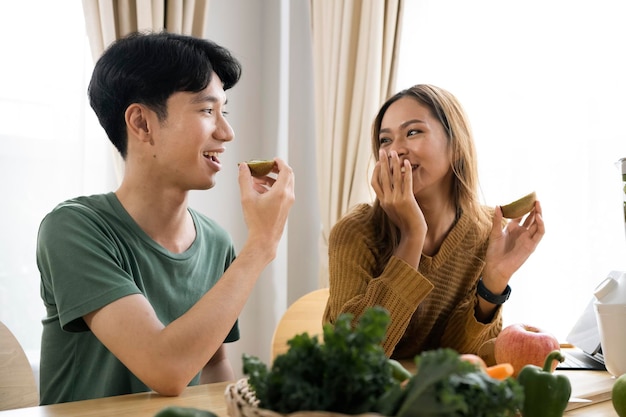 Feliz jovem casal apaixonado fazendo salada saudável na cozinha