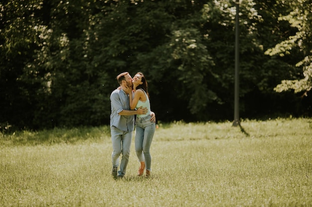 Feliz jovem casal apaixonado no campo de grama