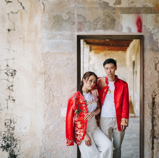Feliz jovem casal asiático ama em vestidos tradicionais chineses - Vermelho é a cor principal do tradicional festivo que inclui casamento na China.