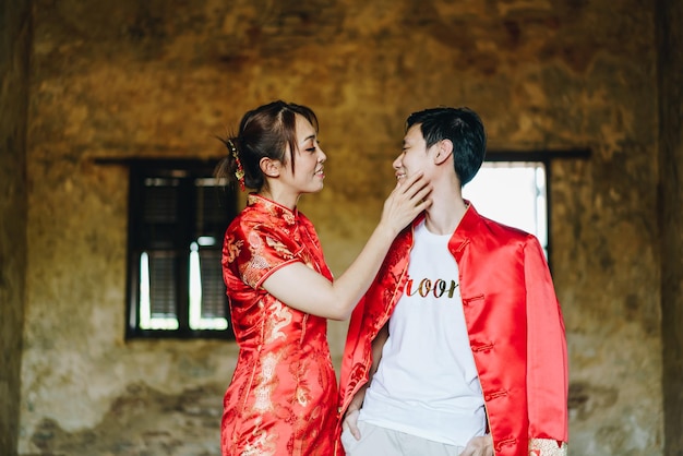 Feliz jovem casal asiático ama em vestidos tradicionais chineses - Vermelho é a cor principal do tradicional festivo que inclui casamento na China.