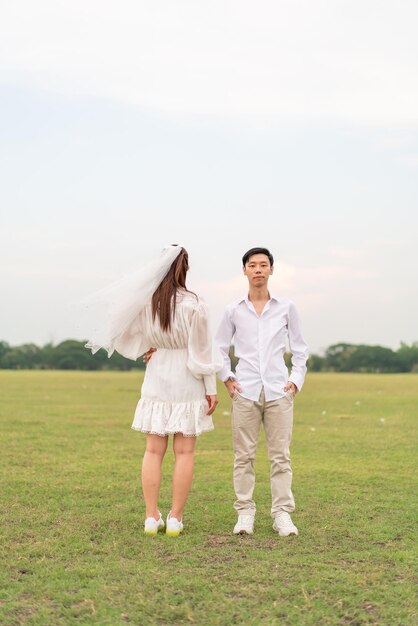 Feliz jovem casal asiático em roupas de noiva e noivo pronto para casar e celebrar o casamento