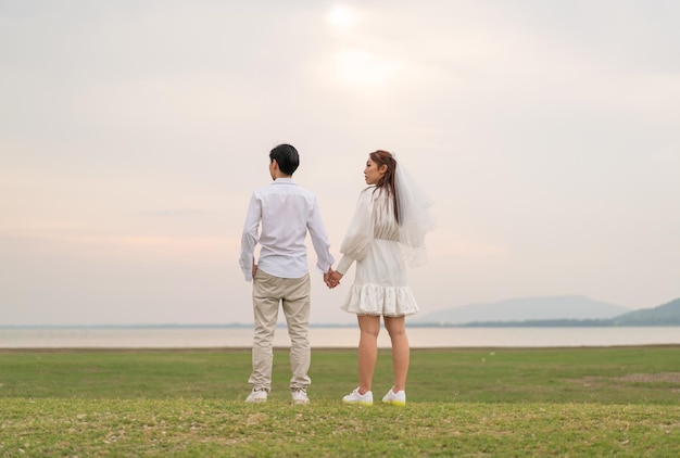 Feliz jovem casal asiático em roupas de noiva e noivo pronto para casar e celebrar o casamento