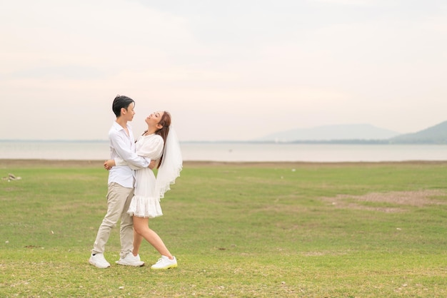 Feliz jovem casal asiático em roupas de noivos