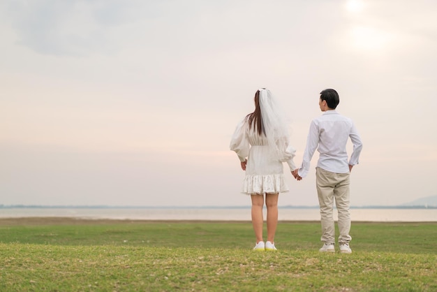 Feliz jovem casal asiático em roupas de noivos