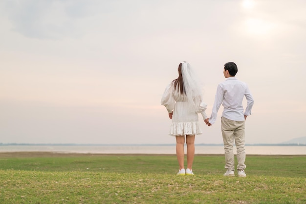 Feliz jovem casal asiático em roupas de noivos