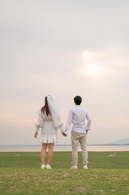 Feliz jovem casal asiático em roupas de noivos