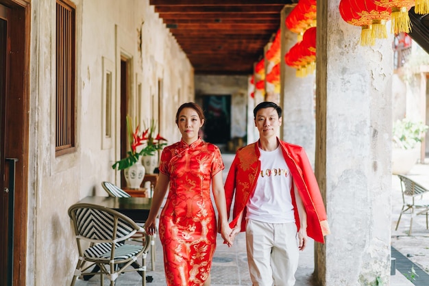 Feliz jovem casal asiático em vestidos tradicionais chineses