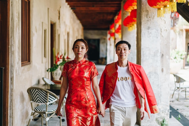 Feliz jovem casal asiático em vestidos tradicionais chineses