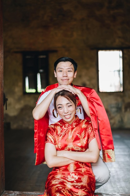 Feliz jovem casal asiático em vestidos tradicionais chineses