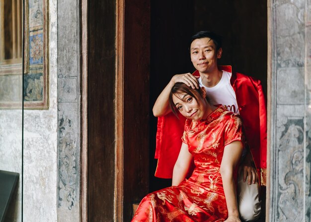 Feliz jovem casal asiático em vestidos tradicionais chineses