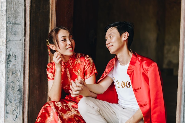 Feliz jovem casal asiático em vestidos tradicionais chineses