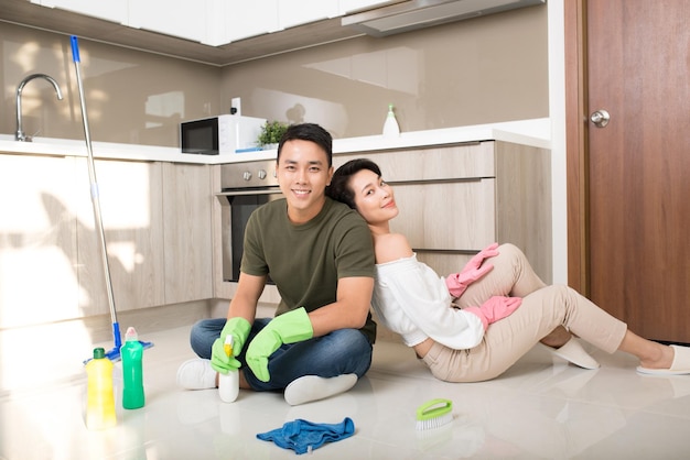 Feliz jovem casal asiático limpando cozinha juntos