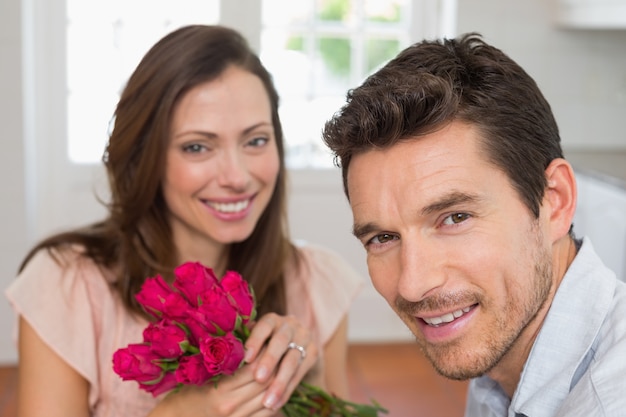 Feliz jovem casal com flores em casa