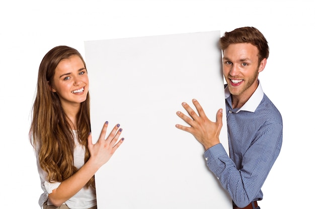 Feliz jovem casal com placa em branco