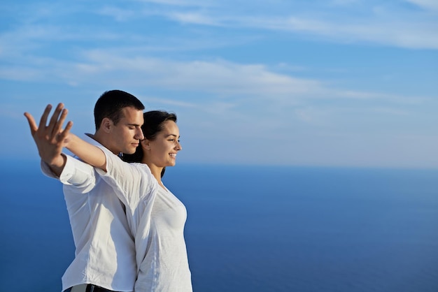 feliz jovem casal romântico divirta-se relaxe sorria na varanda do terraço ao ar livre em casa moderna