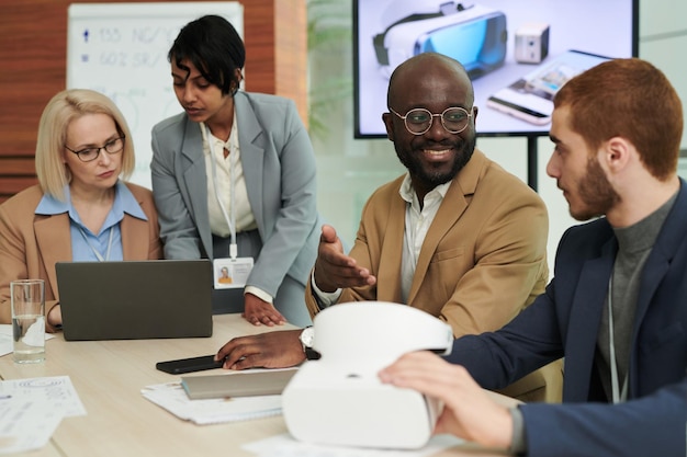 Feliz jovem empresário afro-americano conversando com colega