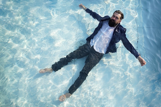 Feliz jovem empresário de terno animado com boas notícias, sortudo vencedor vencedor, celebrando o resultado de vitória de sucesso empresarial na piscina. Empresário com um terno de natação na piscina.