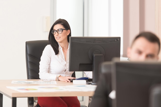 Feliz jovem empresário e mulher trabalham no escritório moderno no computador