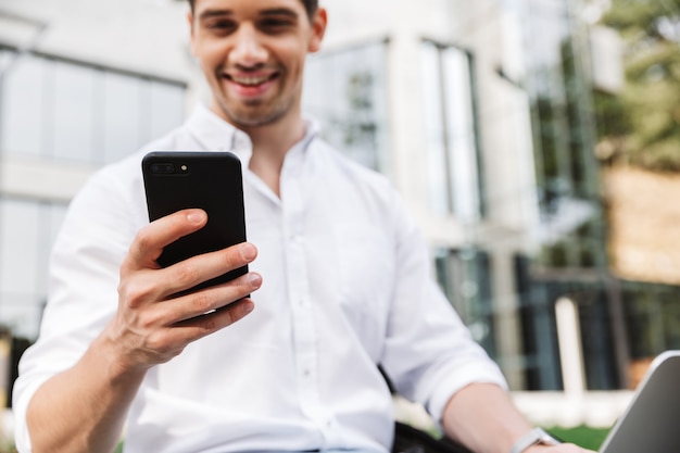 Feliz jovem empresário usando telefone celular