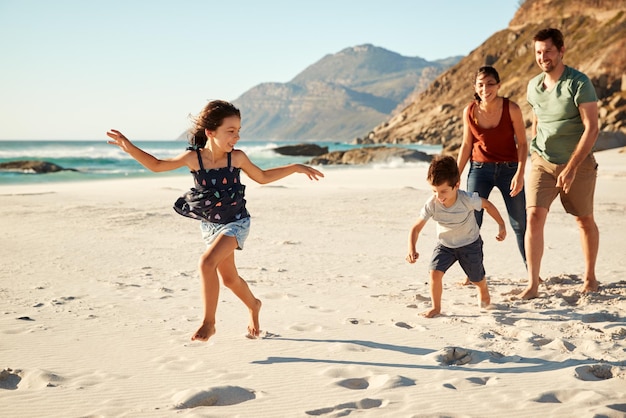 Feliz jovem família branca de férias explorando uma praia juntos em comprimento total