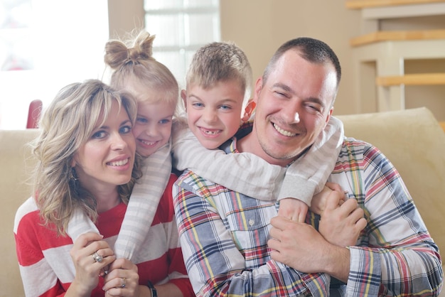 Foto feliz jovem família se diverte com seus filhos na moderna sala de estar em casa dentro de casa