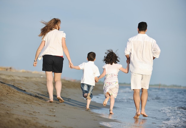 feliz jovem família se diverte e vive um estilo de vida saudável na praia