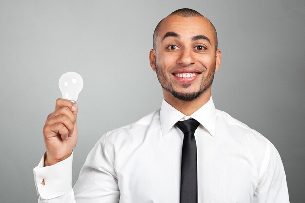 Feliz, jovem, homem negócios, segurando, bulbo leve