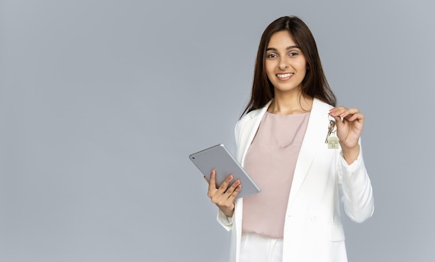 Feliz jovem indiana corretora de imóveis profissional olhando para a câmera segurando a chave