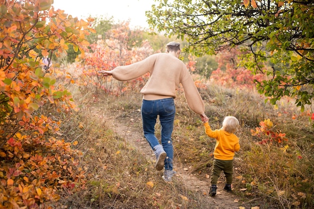 Feliz jovem linda mãe com seu filho pequeno no parque