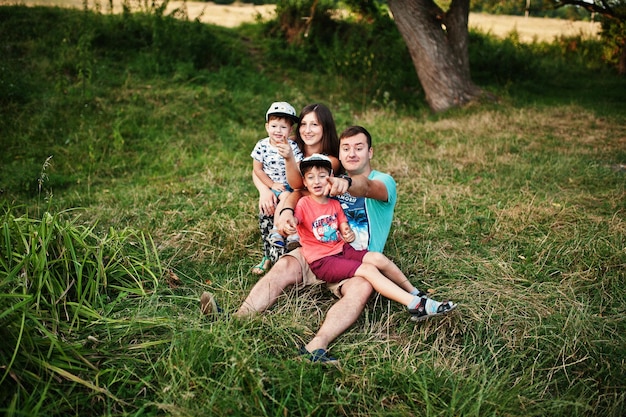 Feliz jovem mãe mãe pai dois filhos filho na natureza se divertindo