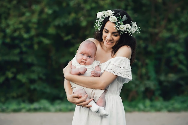 Feliz jovem mãe mantém seu filho recém-nascido nas mãos dela