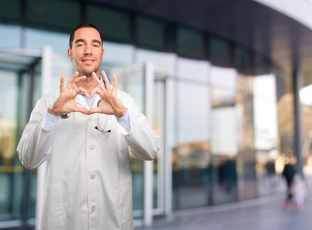 Feliz jovem médico fazendo um gesto de coração