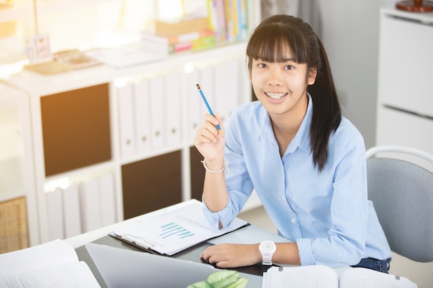 Feliz jovem mulher asiática no escritório