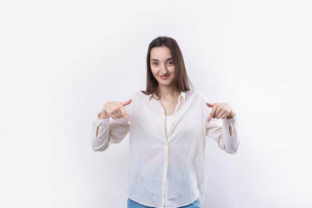 Feliz jovem mulher caucasiana em uma camisa apontando os dedos para longe