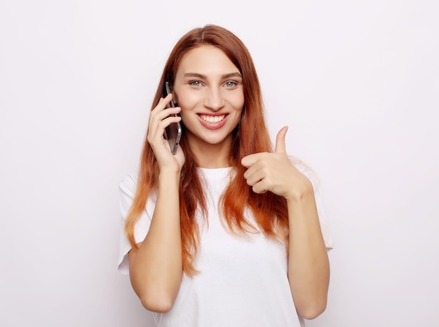 Feliz jovem mulher caucasiana fazendo o polegar no sinal e sorrindo alegremente mostrando seu apoio e respeito a alguém